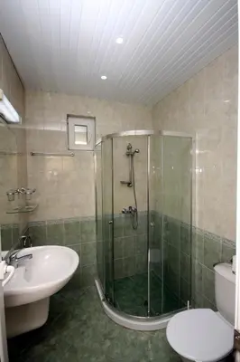 a bathroom with a shower and a sink and a toilet at Hotel Briz in Burgas City