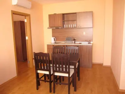 a kitchen with a table and chairs in a room at Hotel COOP Central in Obzor