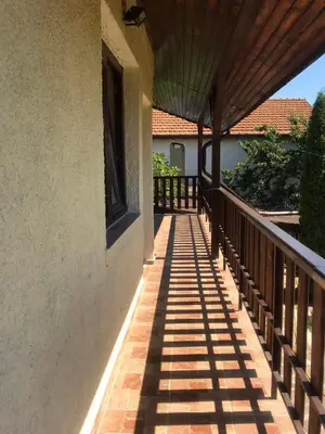 a porch of a house with a wooden railing at Sunset House in Varna City