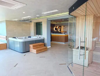 a bathroom with a soaking tub and a kitchen at Paradise Hotel & Relax Center in Pomorie