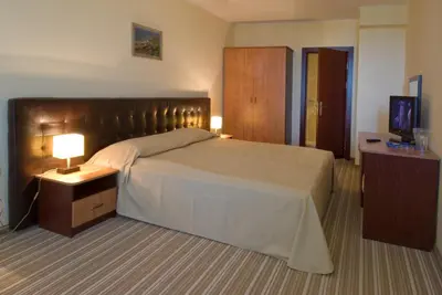 a hotel room with a large bed and a television at Perla Sun Beach Hotel - All Inclusive in Primorsko