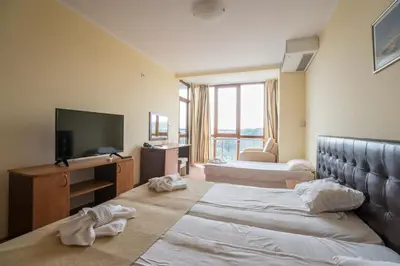 a hotel room with two beds and a television at Perla Sun Beach Hotel - All Inclusive in Primorsko