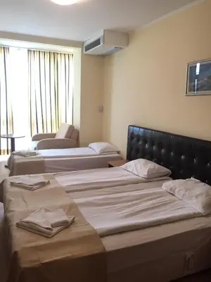 a hotel room with three beds and a couch at Perla Sun Beach Hotel - All Inclusive in Primorsko