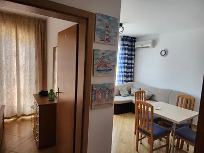 a living room with a table and a couch at Golden Dreams Apartment in Sunny Beach