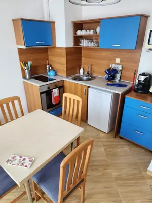 a kitchen with a table and a kitchen with blue cabinets at Golden Dreams Apartment in Sunny Beach
