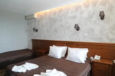 a hotel room with a bed with white pillows at Petrov Family Hotel in Nesebar