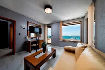 a living room with a couch and a view of the ocean at Petrov Family Hotel in Nesebar