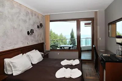 a bedroom with a bed with towels on it at Petrov Family Hotel in Nesebar
