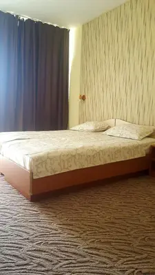 a bedroom with a large bed with a blue curtain at Balaton Hotel in Sunny Beach
