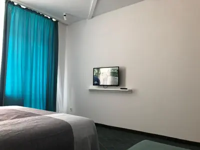 a bedroom with a bed and a tv on a wall at Sunrise Blue Magic Resort - All Inclusive in Obzor