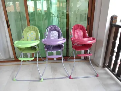 three different colored chairs sitting in front of a window at Arkutino Family Resort in Sozopol