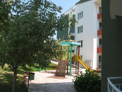 a playground in the courtyard of a building at Green Fort Private Apartments in Sunny Beach