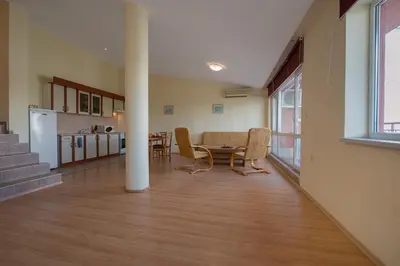 a living room with a table and a kitchen at Green Fort Private Apartments in Sunny Beach