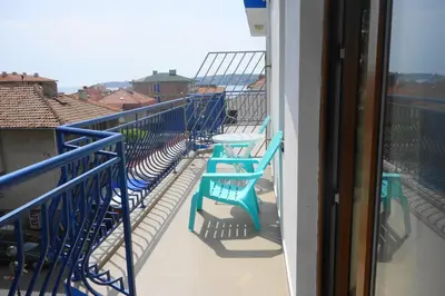 a balcony with blue chairs and a view of a city at Aquamarine in Sozopol