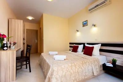 a hotel room with a large bed and a desk at Hotel St Valentine all inclusive in Sunny Beach