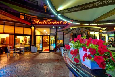 a restaurant with red flowers in front of a building at Hotel St Valentine all inclusive in Sunny Beach