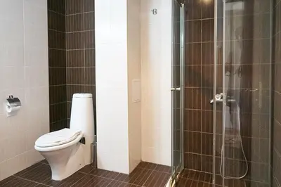 a bathroom with a toilet and a glass shower at Hotel Sea Star Приморско in Primorsko