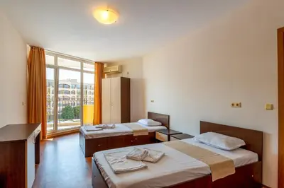 a room with two beds and a large window at Midia Family Resort All-Inclusive in Aheloy