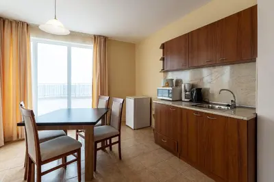 a kitchen with a table and chairs and a kitchen with a sink at Midia Family Resort All-Inclusive in Aheloy