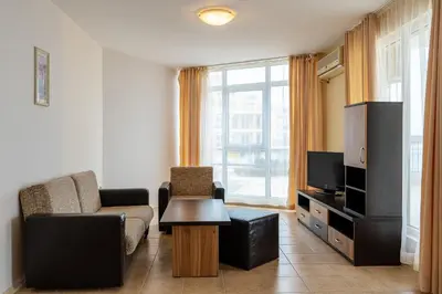 a living room with a couch and a tv at Midia Family Resort All-Inclusive in Aheloy