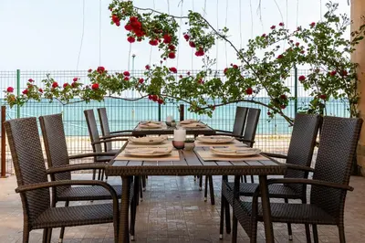 a wooden table with chairs and flowers on a patio at Midia Family Resort All-Inclusive in Aheloy