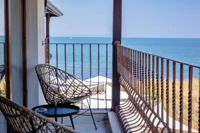 a balcony with a chair and a view of the ocean at Relax Sozopol in Sozopol