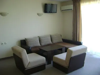 a living room with a couch and a table and chairs at Kandrovi Sozopol in Sozopol