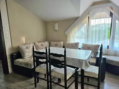 a table and chairs in a living room with a couch at Villa Magnolia in Sozopol