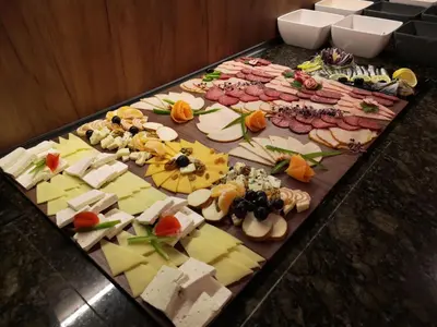 a bunch of different types of cheese on a table at Hotel Golden Tulip Varna in Varna City