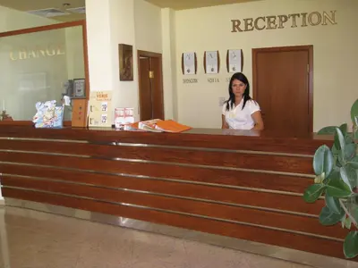 a woman standing at the counter of a dispatcher at Hotel Veris in Sunny Beach