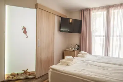 a hotel room with a bed with towels on it at Hugo Hotel in Varna City