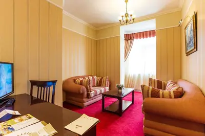 a living room with a table and chairs and a television at Boutique Splendid Hotel in Varna City