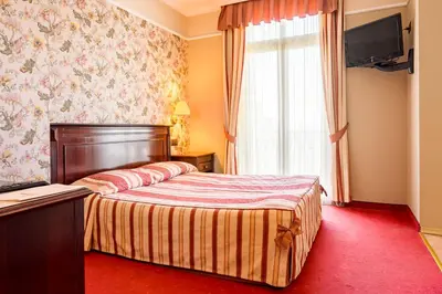 a hotel room with a bed and a window at Boutique Splendid Hotel in Varna City