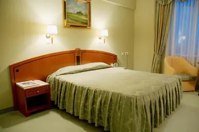 a bedroom with a large bed and a window at Mirage Hotel in Burgas City