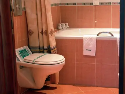 a bathroom with a toilet and a bath tub at Mirage Hotel in Burgas City
