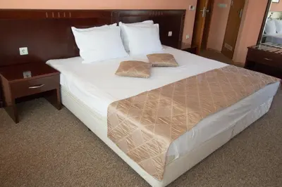 a large bed with two pillows on top of it at Hotel Divesta - self check in in Varna City
