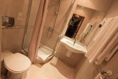 a bathroom with a toilet and a shower and a sink at Hotel Divesta - self check in in Varna City