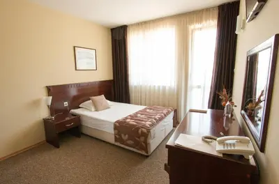 a hotel room with a bed and a desk at Hotel Divesta - self check in in Varna City