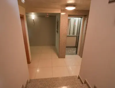 a hallway with a door and a tile floor at Hotel Divesta - self check in in Varna City