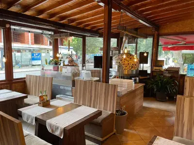 a restaurant with wooden tables and chairs in a room at Sea Horse in Burgas City