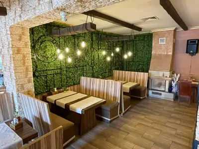 a restaurant with two tables and a green wall at Sea Horse in Burgas City