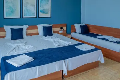 two beds in a room with blue walls at Queen Nelly in Primorsko