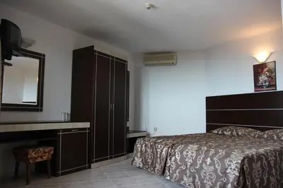 a bedroom with a bed and a dresser and a mirror at Hotel Zora in Sunny Beach