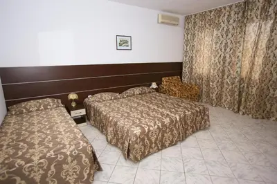 a hotel room with two beds and a window at Hotel Zora in Sunny Beach