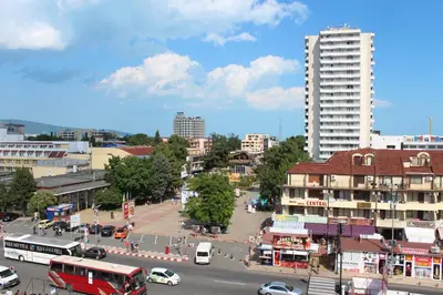 a city with a street with cars and buses at Hotel Atol in Sunny Beach
