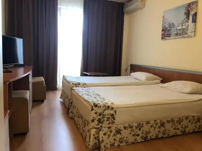 a hotel room with two beds and a television at Hotel Atol in Sunny Beach