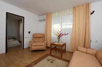 a living room with a couch and a chair and a window at Family Hotel Verona in Sozopol