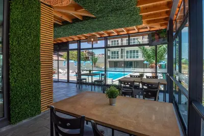 a patio with tables and chairs and a swimming pool at Sveti Dimitar Hotel in Primorsko