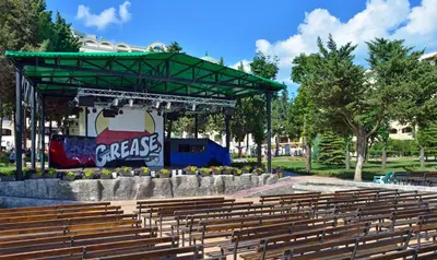 an amphitheater with a stage in a park with wooden benches at Sol Nessebar Bay All Inclusive in Nesebar