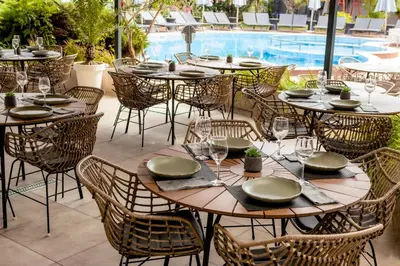 a group of tables and chairs next to a pool at Selena Beach Family Hotel - All Inclusive Light in Sozopol